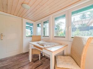 Habitación con mesa blanca, sillas y ventanas en Holiday home with terrace next to the forest, en Allrode