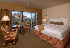 ein Hotelzimmer mit einem Bett, einem Tisch und Stühlen in der Unterkunft Horizon Inn & Ocean View Lodge in Carmel