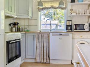 a kitchen with a sink and a dishwasher and a window at Holiday home Hals III in Hals