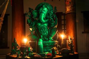 a green statue sitting on top of a table with candles at Casa Nostra Trancoso in Trancoso