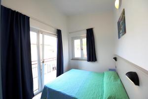 ein Schlafzimmer mit einem grünen Bett und einem Fenster in der Unterkunft Apartments in Peschiera del Garda 22099 in Peschiera del Garda