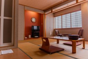 een woonkamer met een tafel en stoelen bij Yuzennoyado Toukai in Ureshino