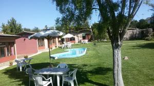 um quintal com uma mesa e cadeiras e uma piscina em Lodging Quirinal em El Tabo