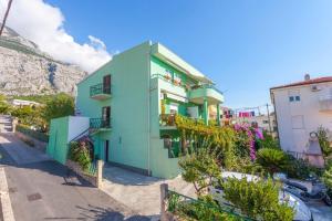 un edificio verde di fronte a una montagna di Apartment Tomislava - ground floor a Makarska