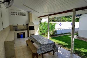 une terrasse avec une table et une cheminée dans l'établissement Tranquilidade a alguns passos da praia - churrasqueira, super wi-fi!, à Matinhos 136 autres photos
