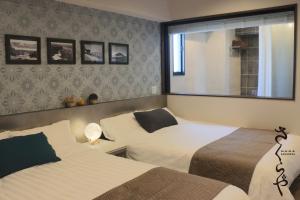 sypialnia z 2 łóżkami i oknem w obiekcie さくらや w mieście Okinawa