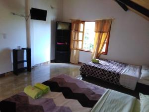 a living room with two beds and a window at Cabaña El Trebol in San Agustín