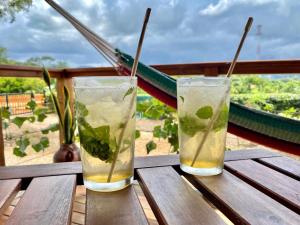 two drinks are sitting on a wooden table at Hoja Azul in Hojancha
