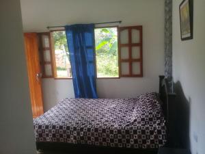 um quarto com uma cama e duas janelas em Cabaña El Trebol em San Agustín