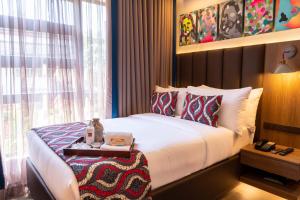 a hotel room with a bed and a window at UNWND Boutique Hotel Makati in Manila