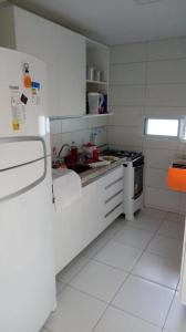 a white kitchen with a stove and a refrigerator at Varandas do Francês in Maceió