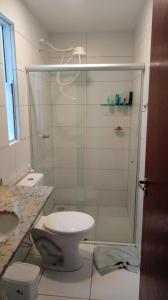 a bathroom with a toilet and a glass shower at Varandas do Francês in Maceió
