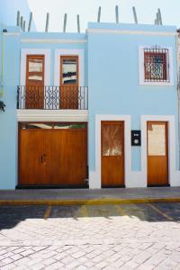 - un bâtiment bleu avec des portes en bois dans une rue dans l'établissement Casa Olié, à Oaxaca