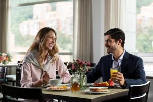 un hombre y una mujer sentados en una mesa en un restaurante en Hotel bh Usaquén, en Bogotá