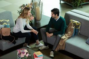 a man and woman sitting on couches in a living room at Hotel bh Usaquén in Bogotá