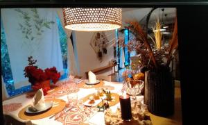 a dining room table with a hat and glasses and a lamp at Mamy Cherie in Rodrigues Island