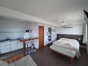 a bedroom with a bed and a table and a kitchen at Cabañas Agreste in Villa Gesell