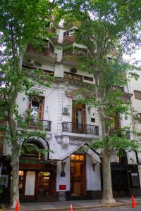 un edificio alto y blanco con árboles delante en Anchorena Appart en Buenos Aires