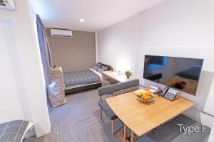 een kleine woonkamer met een tafel en een televisie bij Hermitage Nishi Shinjuku in Tokyo
