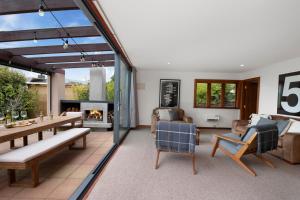 a living room filled with furniture and a fireplace at Waters Edge Retreat - Motuoapa Holiday Home in Turangi