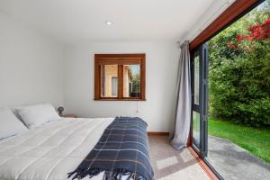 a bedroom with a bed and a window at Waters Edge Retreat - Motuoapa Holiday Home in Turangi