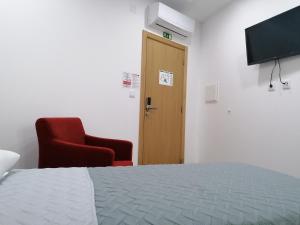 Uma televiso e/ou sistema de entretenimento em ALOJAMENTO GIRASSOL - Guest House - Quarto com casa de banho privativa