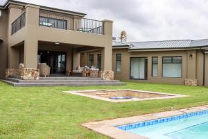 a house with a swimming pool in front of it at Stone`s Throw Manor in Muldersdrift