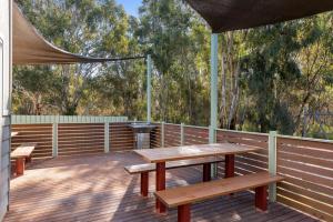 a wooden deck with benches and a canopy on it at Discovery Parks - Echuca in Echuca