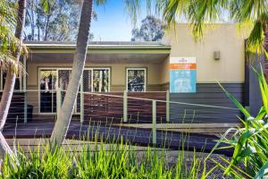 a building with palm trees in front of it at Discovery Parks - Echuca in Echuca