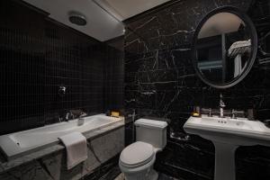 a bathroom with a toilet and a sink and a mirror at La Sinfonía del Rey Hotel & Spa in Hanoi