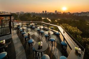 a row of tables on a balcony with the sunset at La Sinfonía del Rey Hotel & Spa in Hanoi