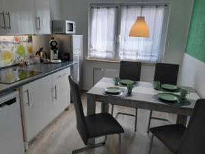 a kitchen with a table and chairs in a kitchen at Ferienwohnung Jasmin in Hannover +26 photos
