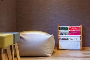 a bed with a pillow next to a book shelf at Kamo River J~House in Kyoto +33 photos