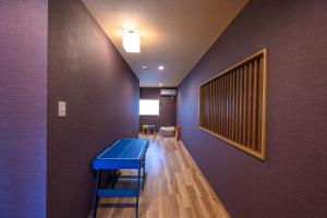 a hallway with a blue table and a wall at Kamo River J~House in Kyoto