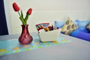 a table with a vase and a container of candy and flowers at KT Knight Hotel in Surin