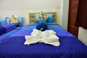 een blauw bed met witte handdoeken erop bij KT Knight Hotel in Surin