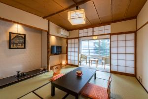 une chambre japonaise avec une table et une salle à manger dans l'établissement Senkeien Tsukioka Hotel, à Kaminoyama