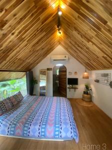 a bedroom with a large bed with a wooden ceiling at Phố Đá Hotel in Lagi