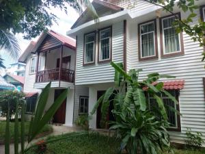 a white house with a balcony at Manoha Villa in Sihanoukville