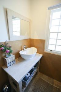y baño con lavabo blanco y espejo. en Jacaranda Wine And Guestfarm, en Wellington