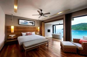 شاطئ ومنتجع سبا ذا تاراس في جزيرة رداغ: غرفة نوم مع سرير وإطلالة على المحيط