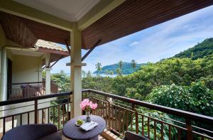 Un balcón con una mesa con flores. en The Taaras Beach & Spa Resort, en Redang Island