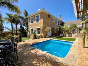 a swimming pool in front of a house at Mountainview Guesthouse in Cape Town