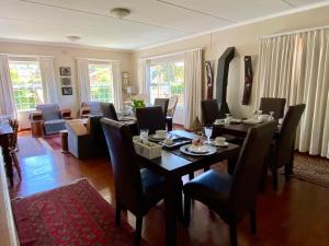 a dining room with a table and chairs and a living room at Mountainview Guesthouse in Cape Town