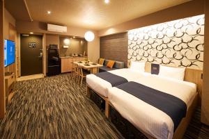 ein Hotelzimmer mit einem großen Bett und einer Küche in der Unterkunft MONday Apart Premium AKIHABARA in Tokio