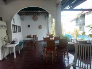 ein Esszimmer mit Stühlen und einem Tisch sowie ein Tisch und Stühle in der Unterkunft Manoha Villa in Sihanoukville