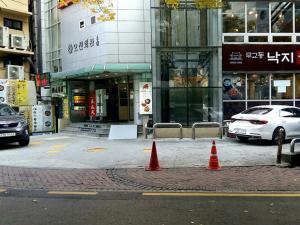 dos conos de tráfico naranja en una calle frente a un edificio en 24 Guesthouse Seoul City Hall, en Seúl