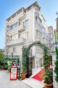 ein weißes Gebäude mit einem Bogen davor in der Unterkunft Beyazit Palace Hotel Cafe & Restaurant in Istanbul