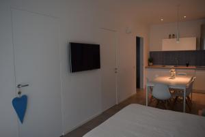 a bedroom with a bed and a table and a kitchen at Villa Alcova in Caorle