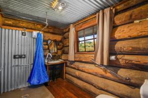 a log cabin room with a desk and a window at Dargo Hotel in Dargo